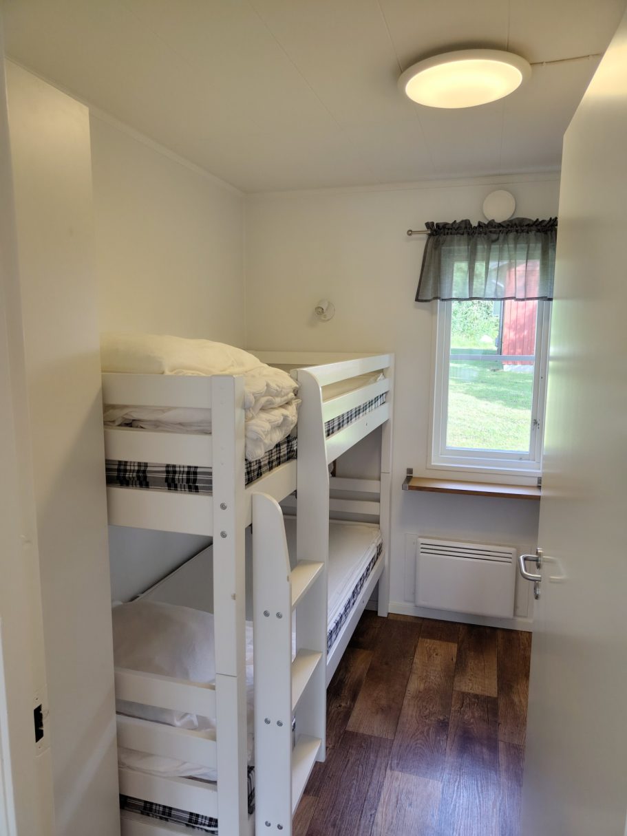 Sovrum 2 Ljust rum med våningssäng och fönster mot trädgården.