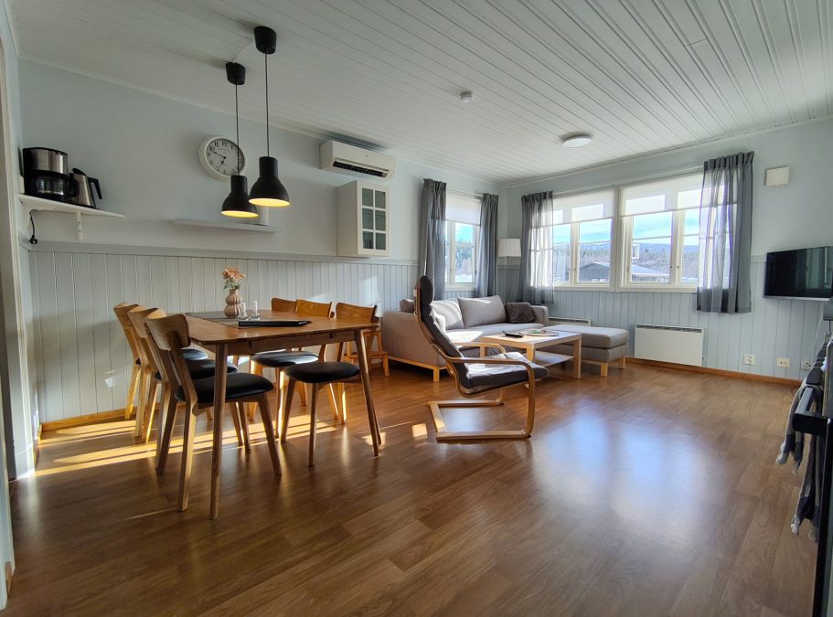 Matrum och vardagdrum Ljust och luftigt vardagsrum med matbord, stolar, sofa och fönster.