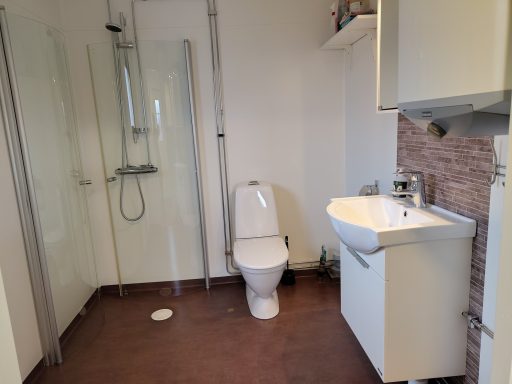 Badrum med dusch, toalett och handfat i modern stil.