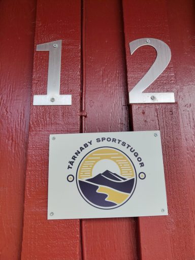 Nummer 12 på ytterdörr med en logotyp och en bergsdesign.