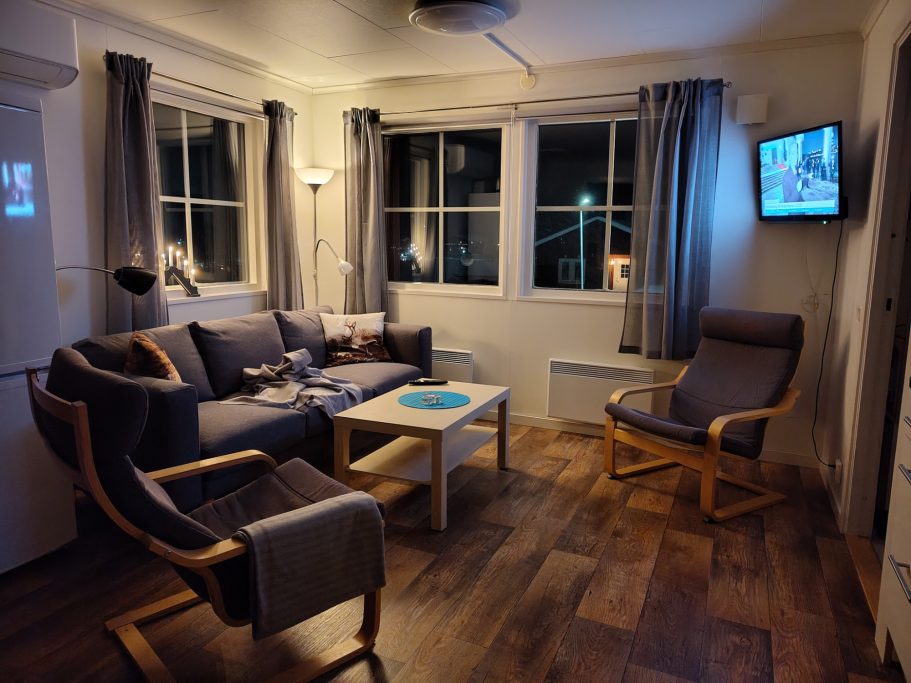 Vardagsrum Mysigt rum med soffa, fåtöljer, ett bord och TV. Flera fönster släpper in ljus.