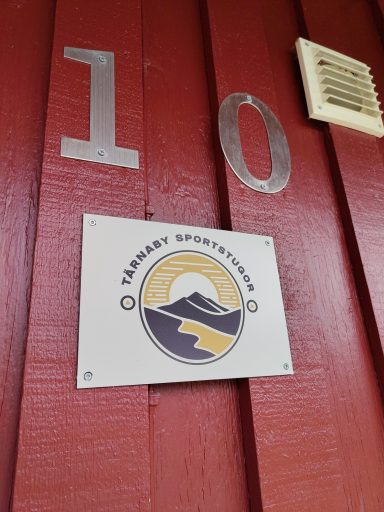 Skylt med nummer 10 och en logotyp med bergs- och solmotiv.