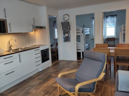 Kök med matplats och vardagsrum, moderna möbler i ljusa färger.